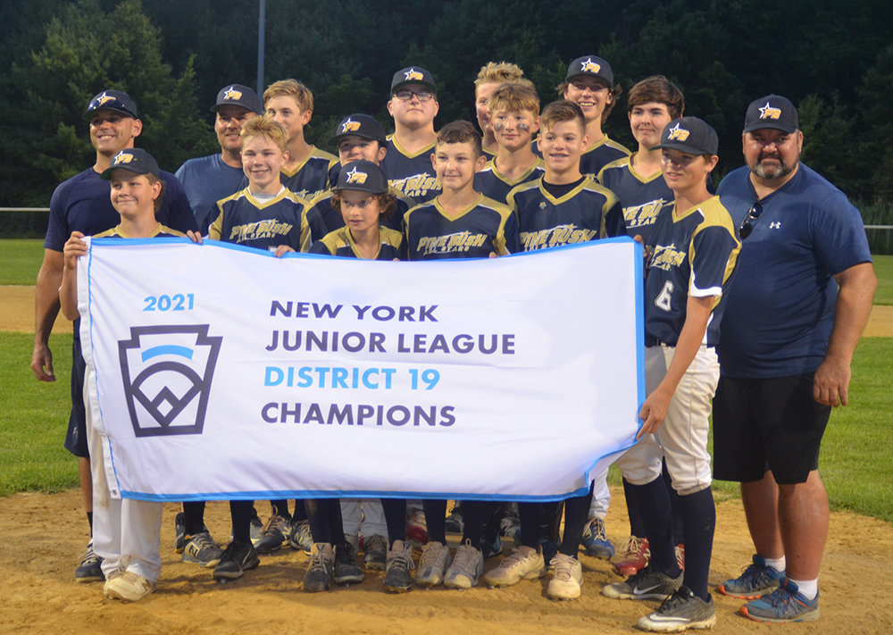 Pine Bush poses with the District 19 championship flag after beating Wallkill Area, 12-2, in the championship game on Wednesday at Pine Bush Town Park.